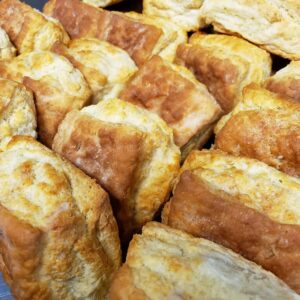 A tray of freshly baked, golden brown biscuits.