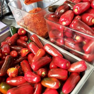 Bright red jalapeños being turned into house made sriracha